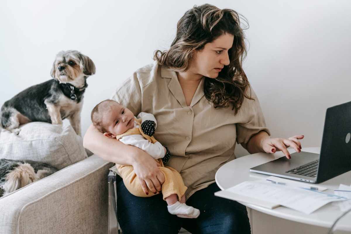 Mamma che lavora con figlio in braccio