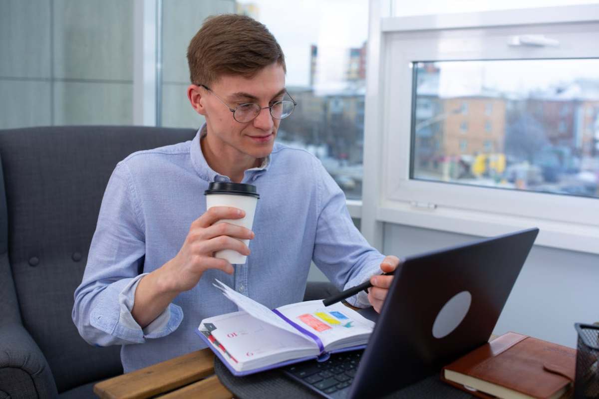 Persona al lavoro mentre beve un caffè