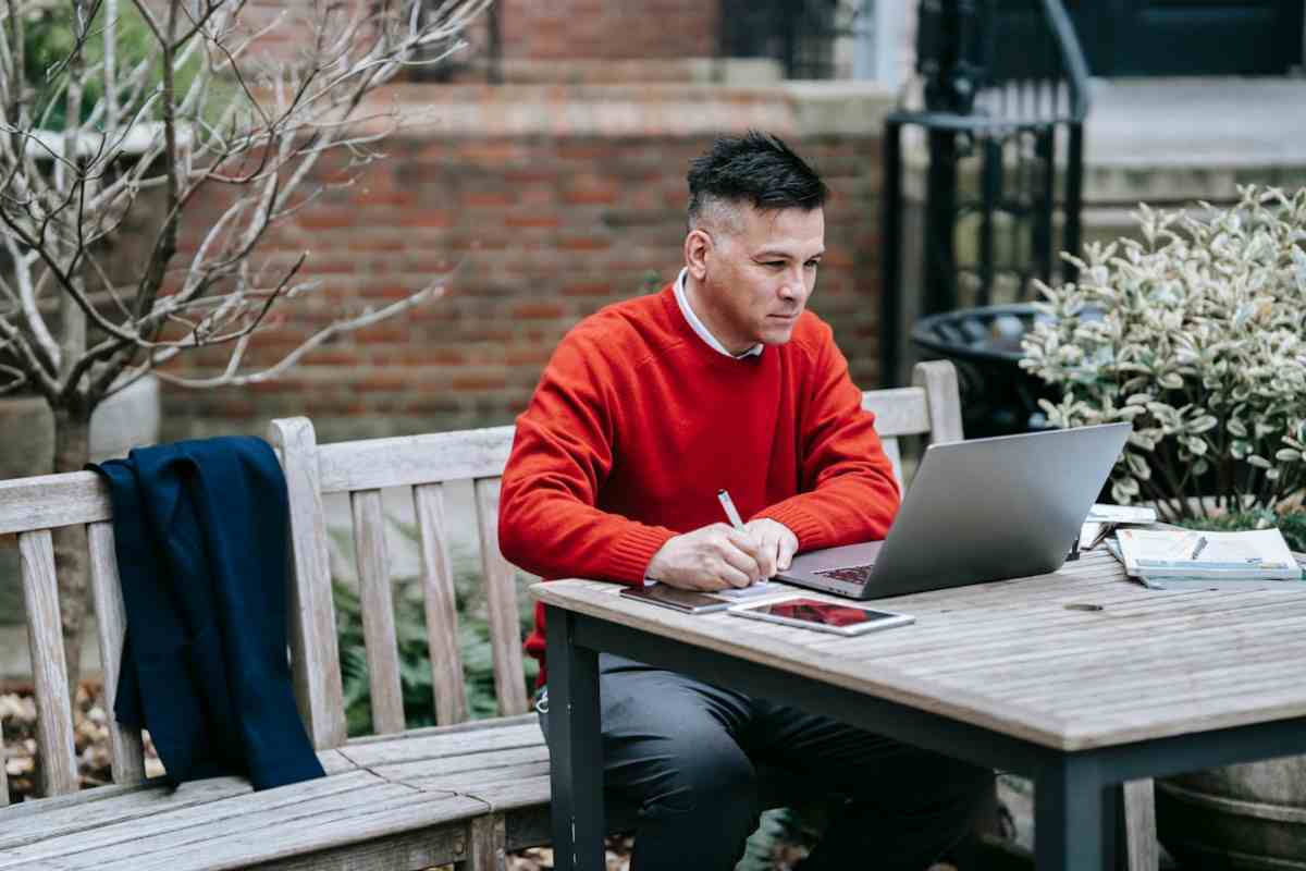 Persona che legge al computer e prende appunti