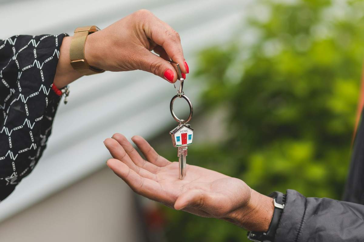 Persone che si passano un portachiavi raffigurante una casa