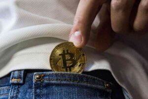 Persona che mette un Bitcoin in una tasca